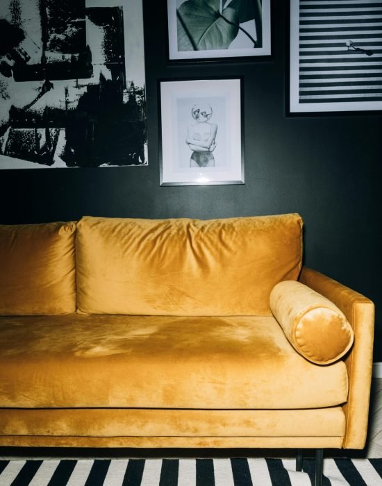 Chic living room featuring a yellow velvet sofa with contemporary art on the wall.